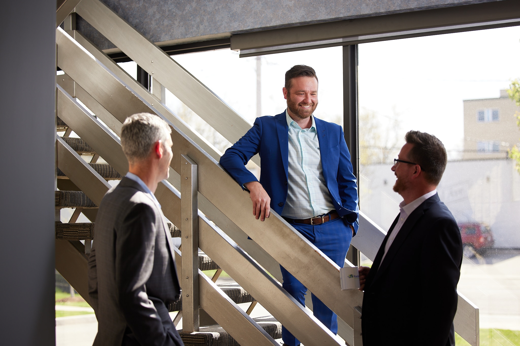 An image of three Ford Keast LLP team members having a candid conversation at the stairs in their London, Ontario office.
