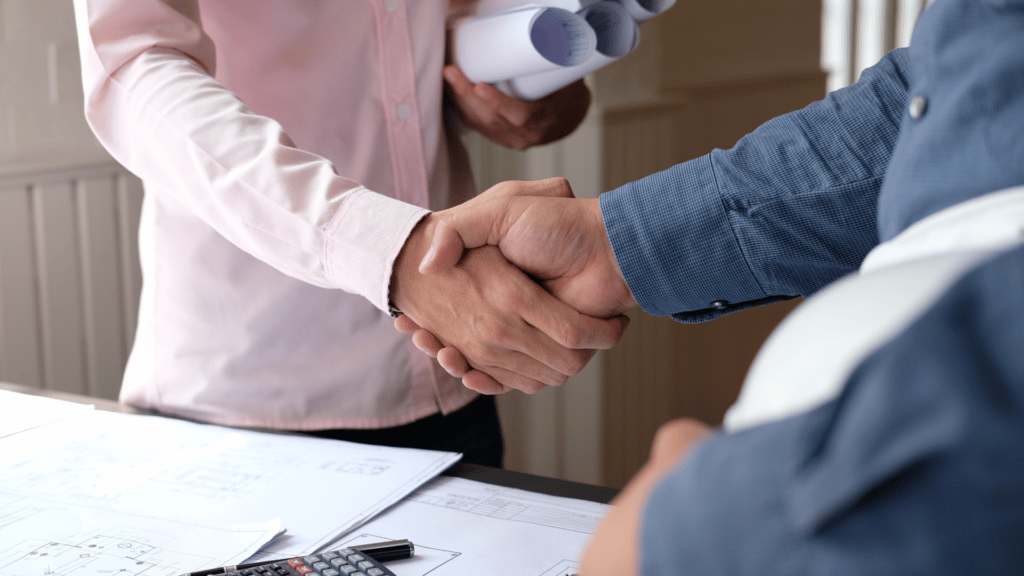 An image of a small business owner shaking hands with their contractor or employee