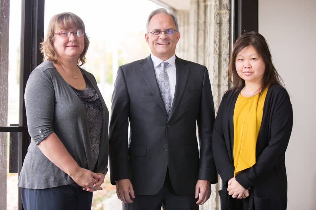 Three Ford Keast LLP team members standing together in the London office.