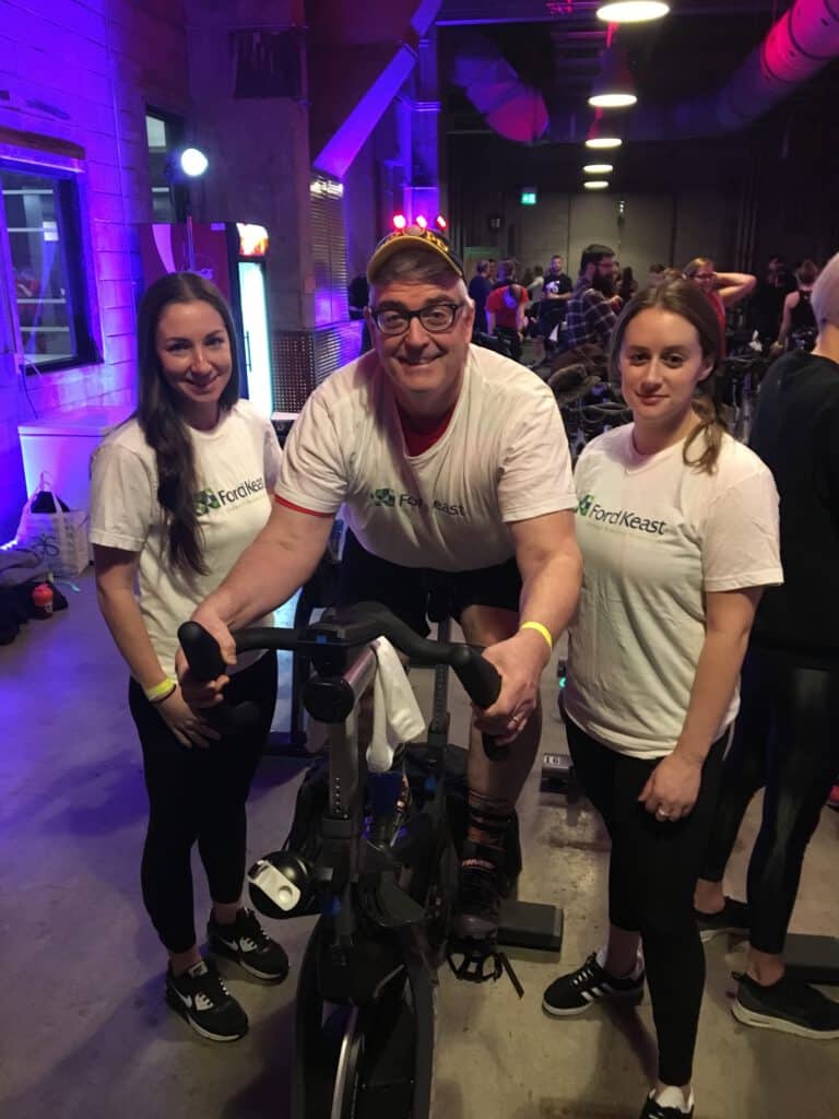 Three Ford Keast LLP staff members participating at a spin class event