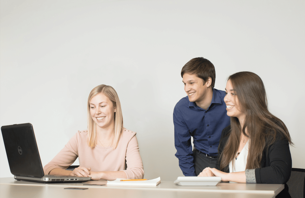 An image of three Ford Keast LLP team members collaborating and working on a client engagement project in the London, Ontario office.