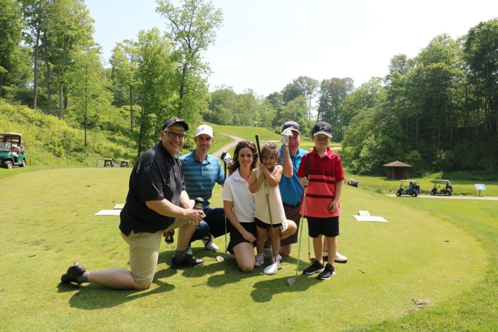 An image of the Ford Keast Team and children at the Turk Turley Memorial Golf Tournament