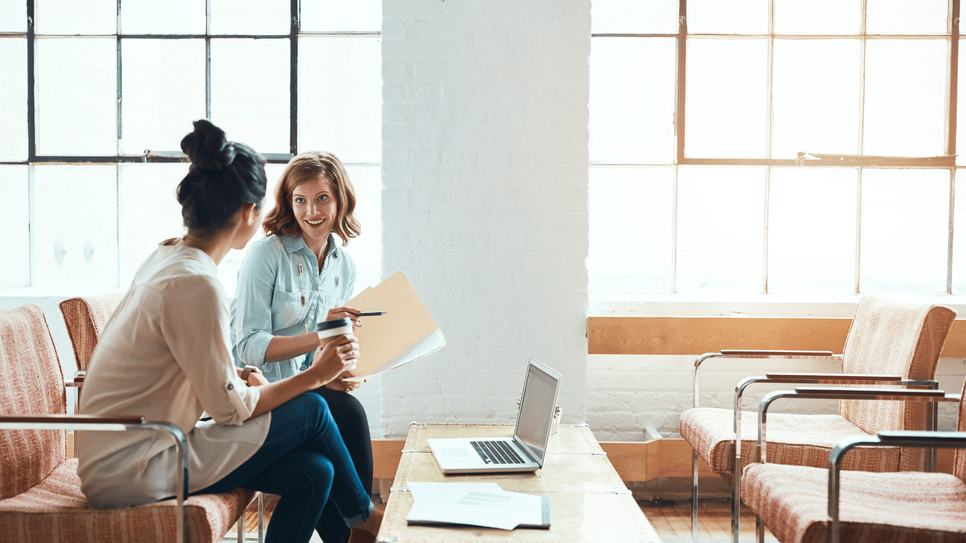 Two family members sitting on a couch in an office in London discussing their family trust and estate plan