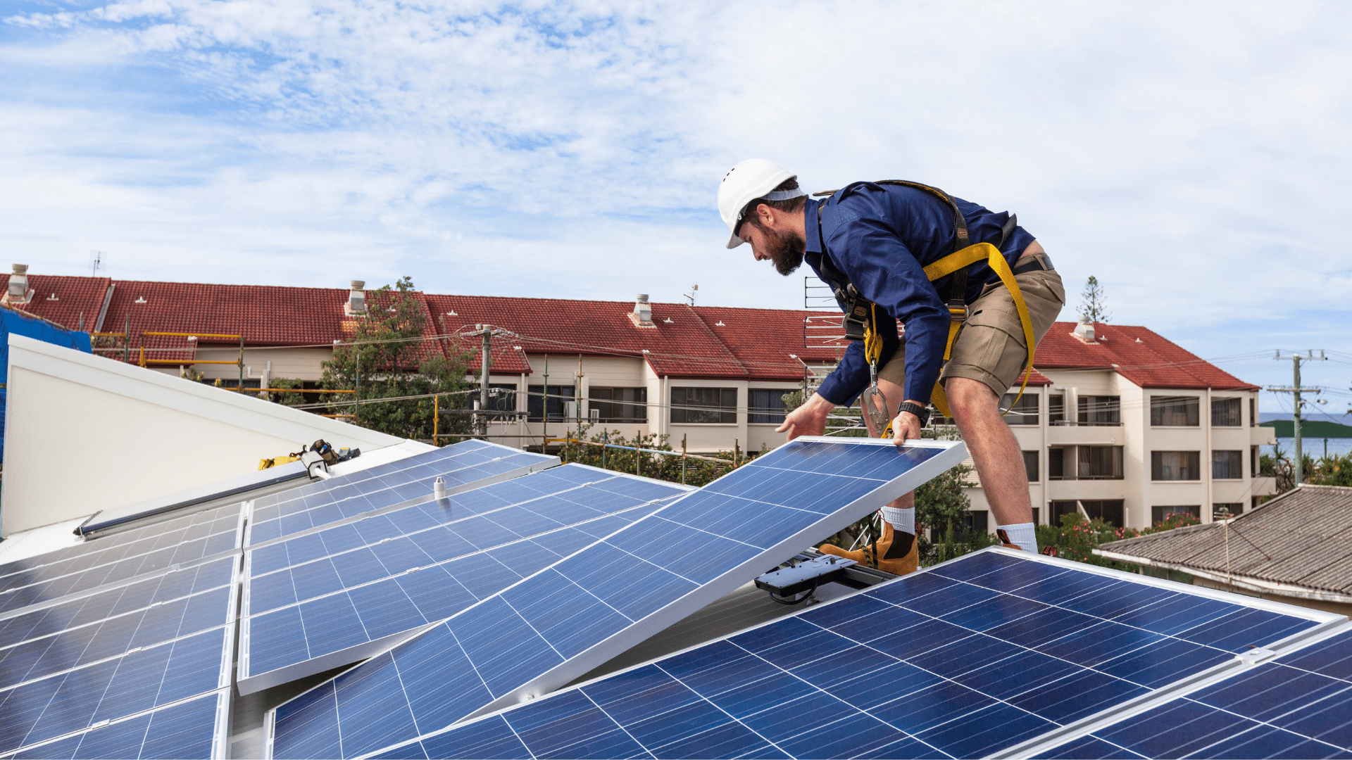 An image of a worker installing solar panels on a local London Ontario business as part of the CGAH program
