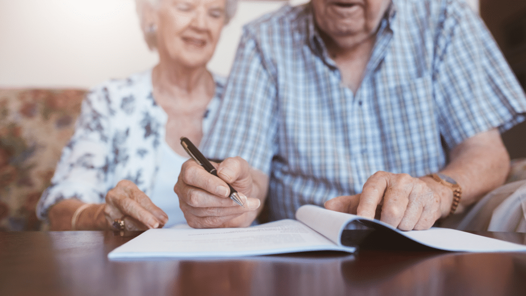 An image of an elderly couple chatting with the executor of their will