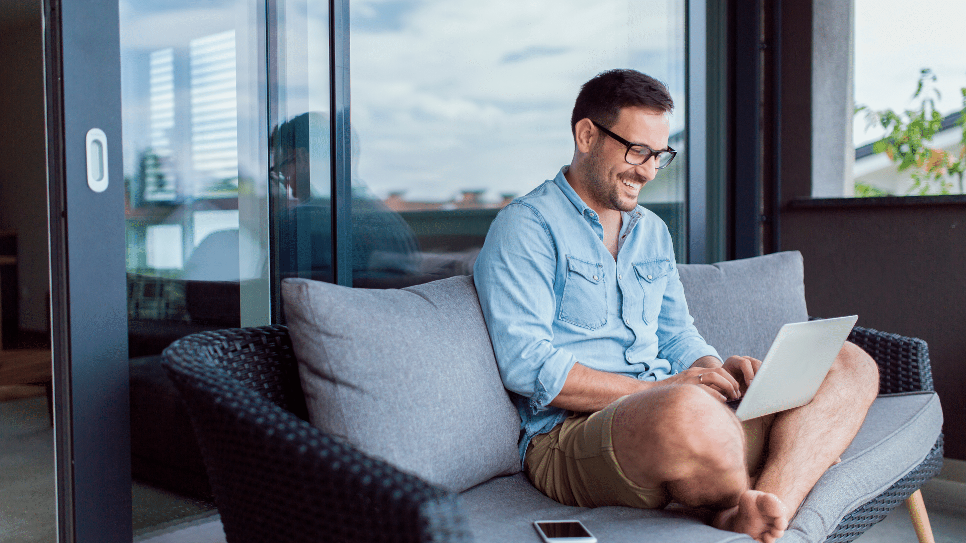 An image of a remote worker working on their couch in the tropics