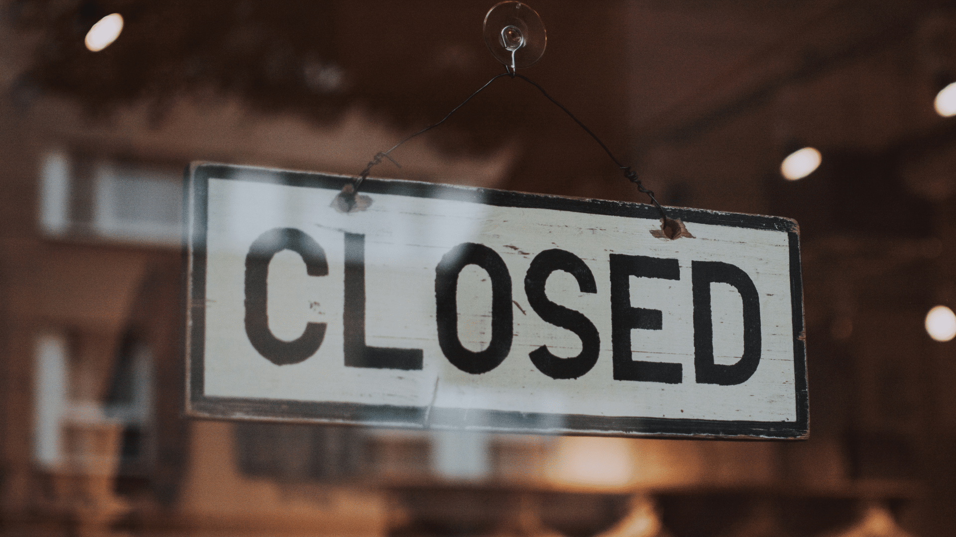 An image of a small business with a closed sign in it's window.