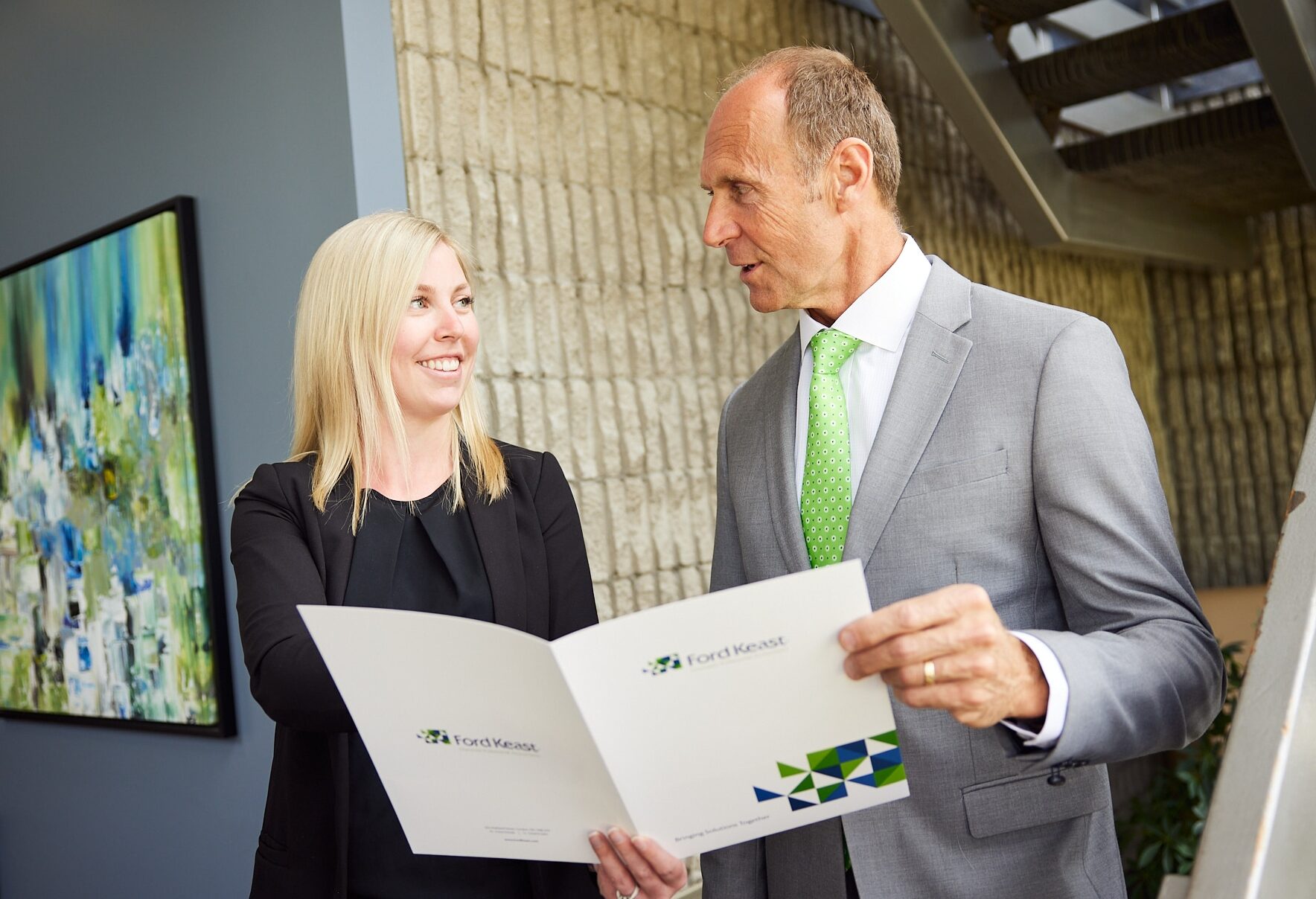 An image of two Ford Keast LLP employees having a conversation in the London office lobby.