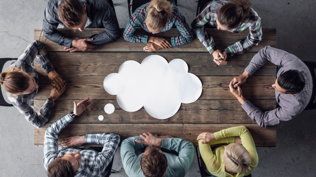 An overview image of a board table with a team meeting taking place.